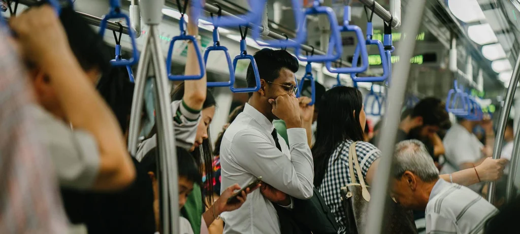 people on a train holding onto the strap hangers