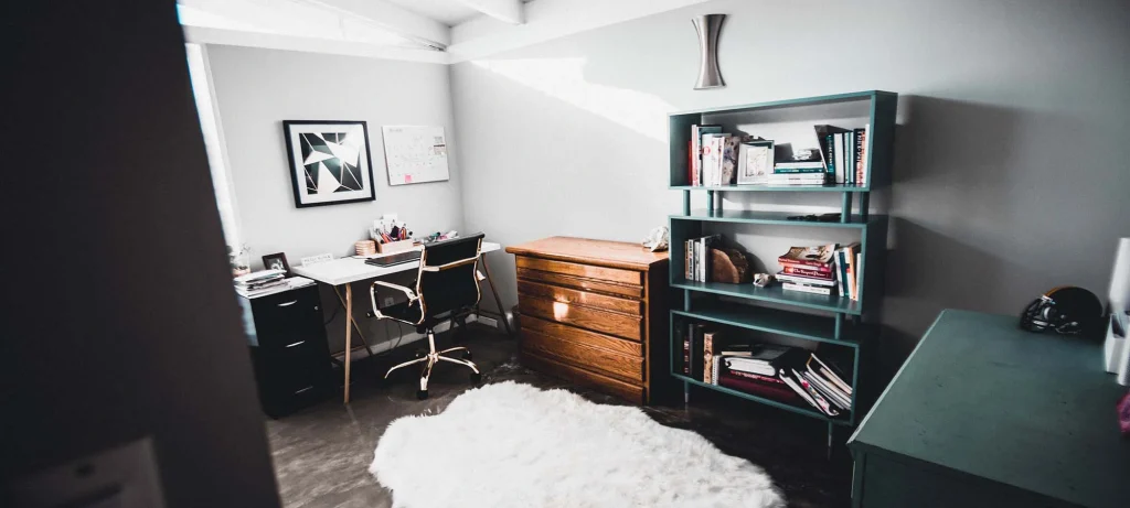 bedroom with desk, shelves, cabinets and a rug on the floor