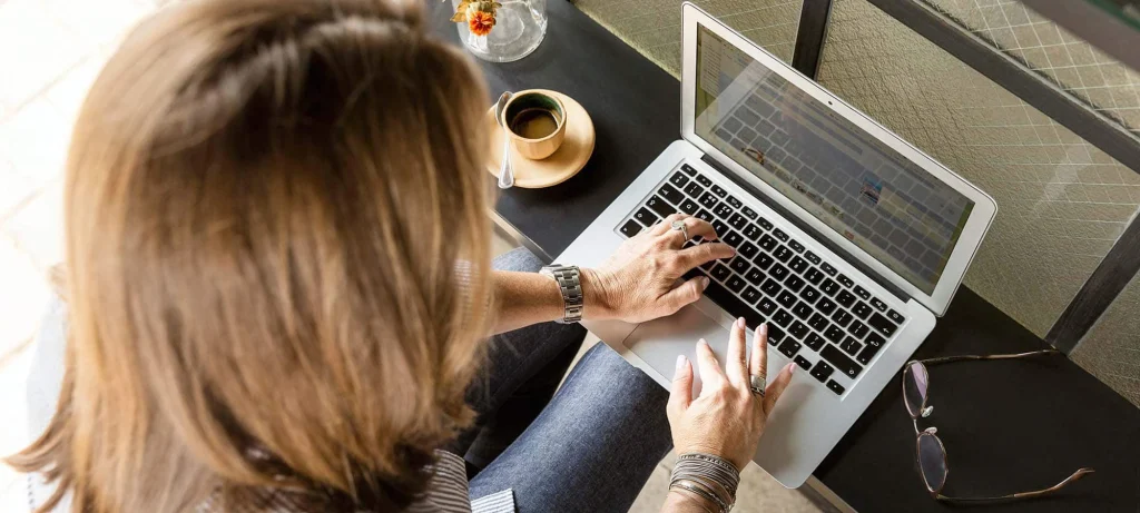 woman working on her laptop with a cup of tea next to her