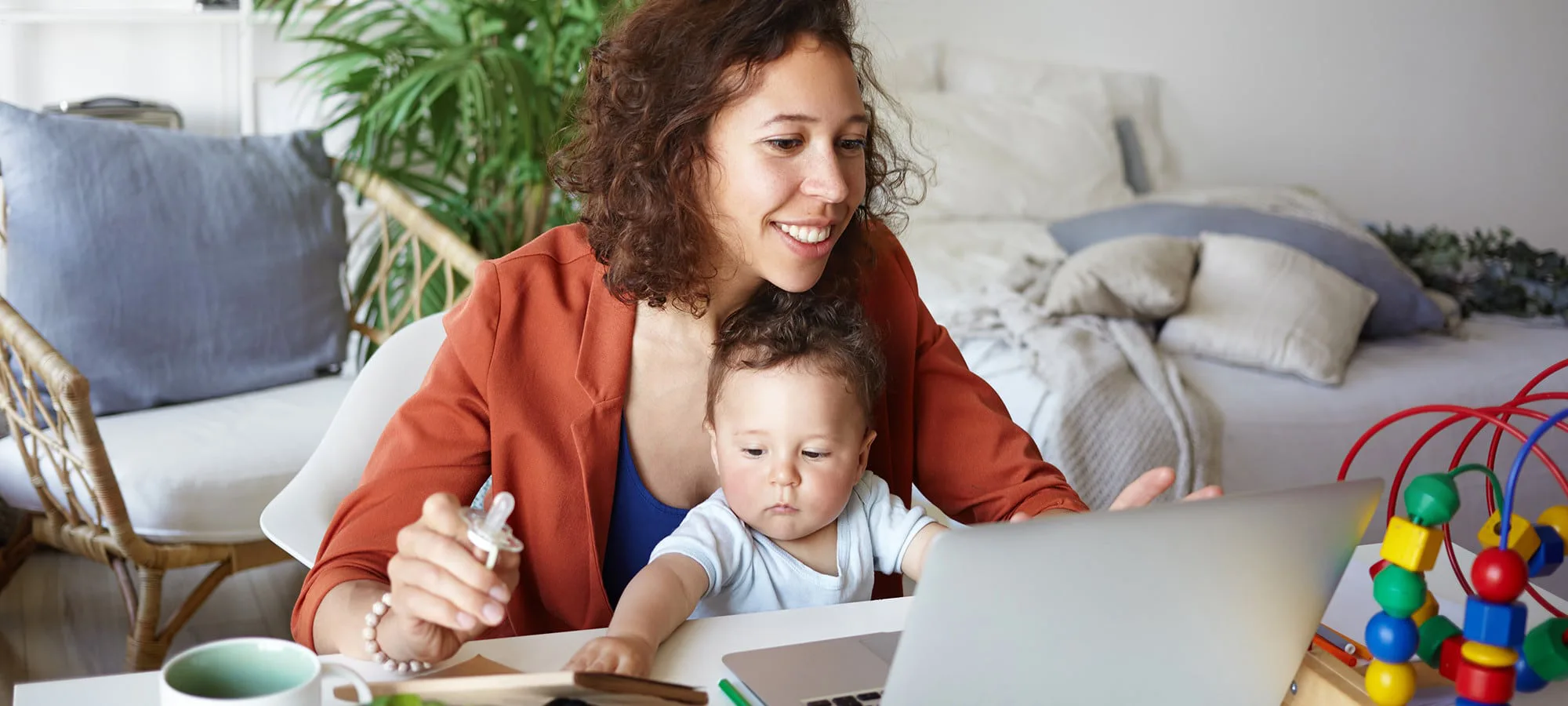 mother and child sat in front of a laptop in a living room