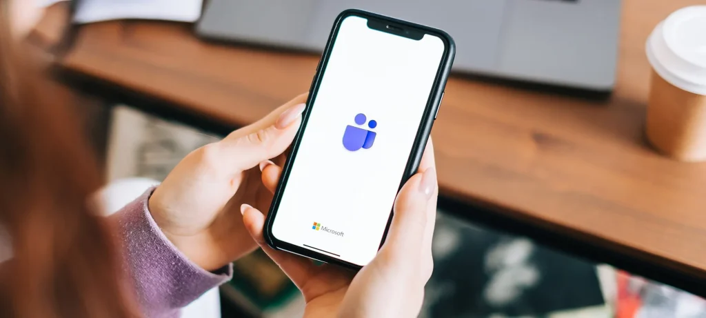 person holding phone and looking at teams app