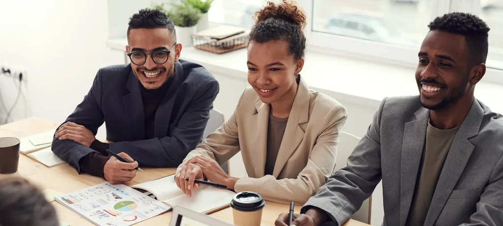 three young professionals sat together at an office desk